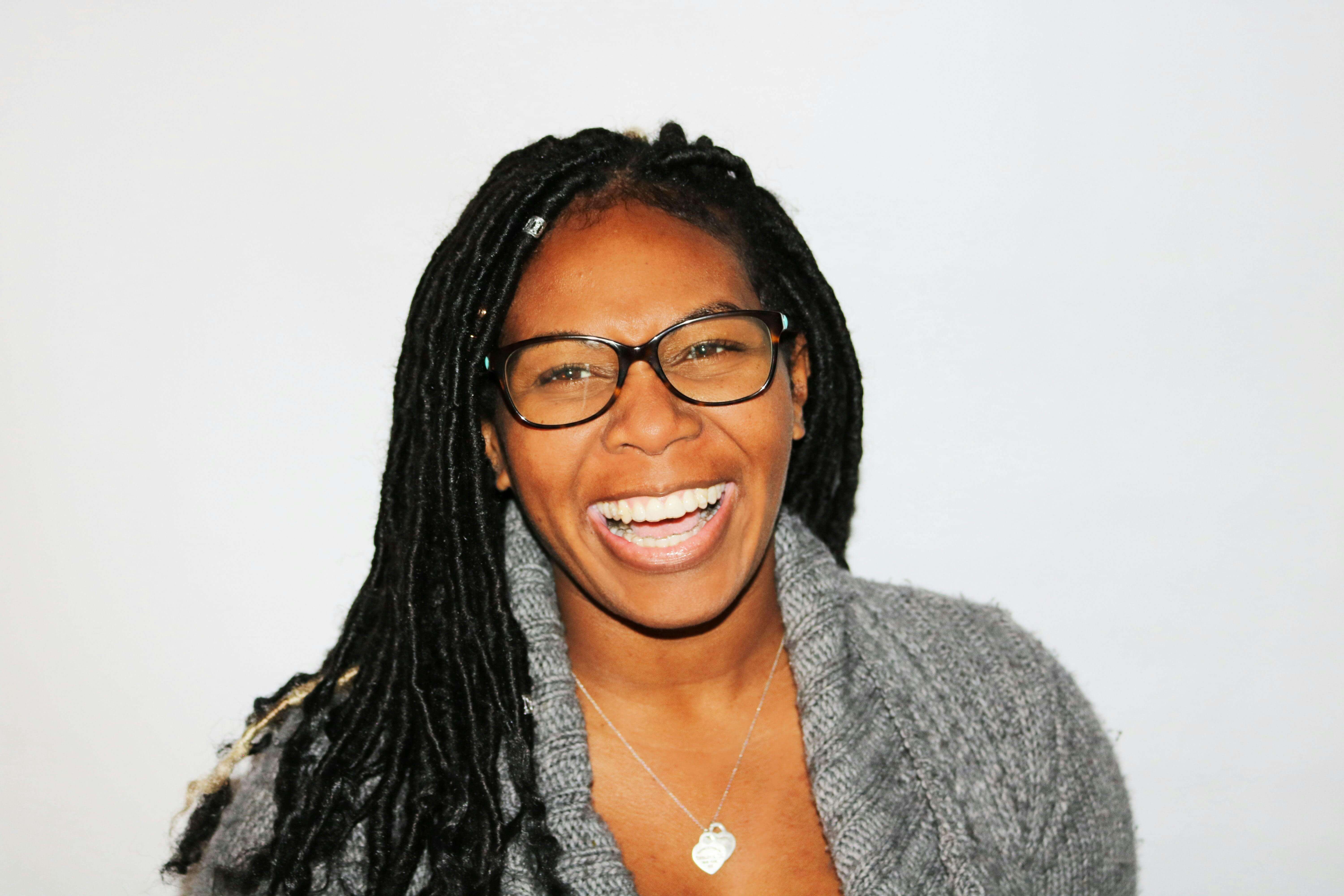 smiling woman wearing white and black pinstriped collared top
